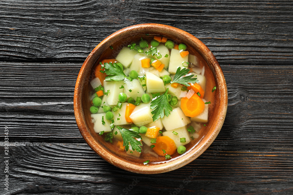 Bowl of fresh homemade vegetable soup on dark wooden background, top view Bowl of fresh homemade vegetable soup on dark wooden background, top view