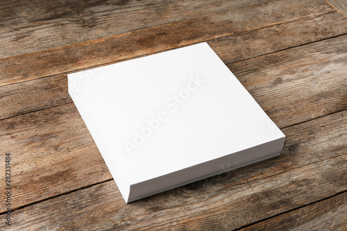 Stack of blank paper sheets for brochure on wooden background. Mock up