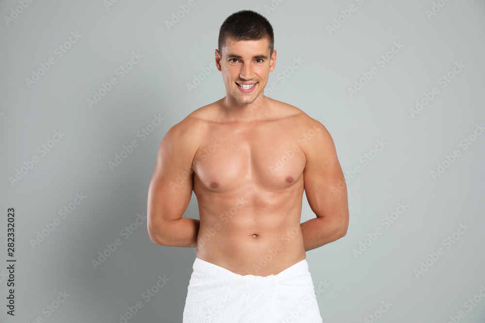Young man with slim body on grey background