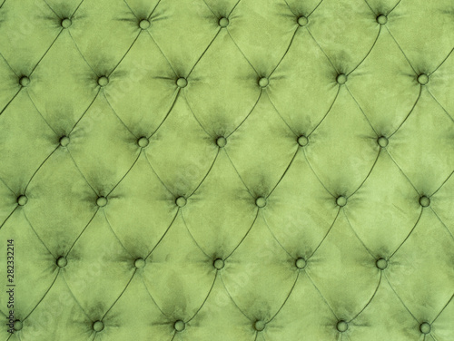 Green abstract background with symmetrical upholstered buttons on fabrics.
