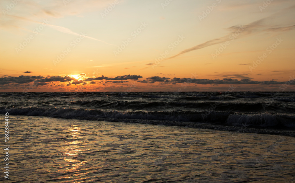 Obraz premium Baltic sea at sunset with waves