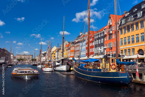 Sightseeing boat sailing by the harbour Nyhavn of Copenhagen