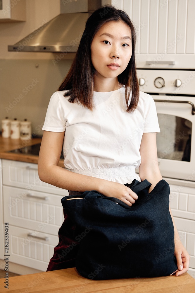 Asian Young Woman Taking Out Groceries from Bag Asian Young Woman Taking Out Groceries from Bag