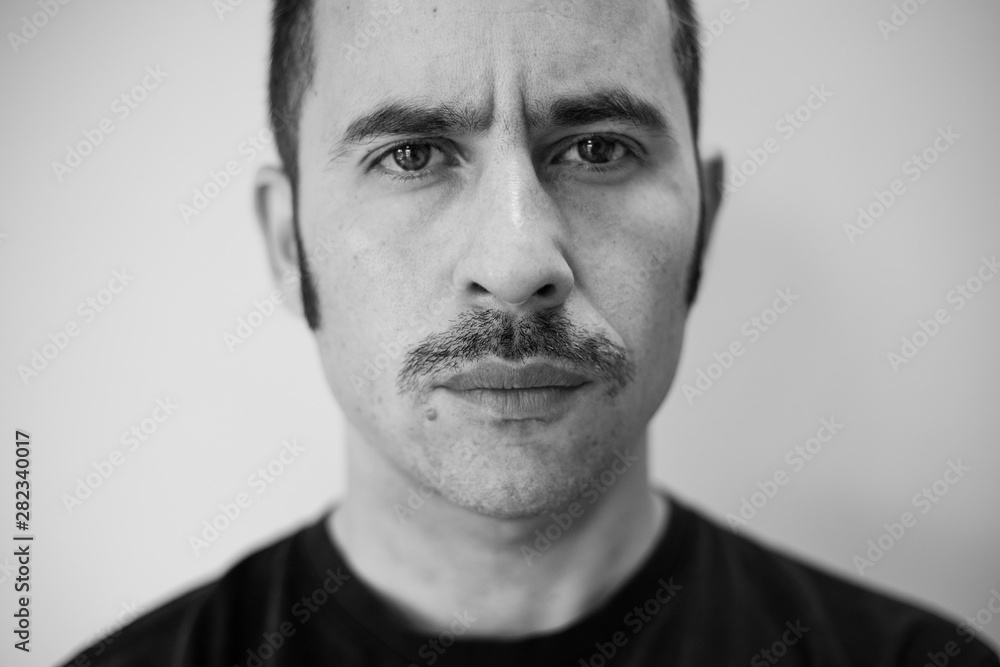 White man with a prominent mustache looking straight at the camera against a seamless background White man with a prominent mustache looking straight at the camera against a seamless background