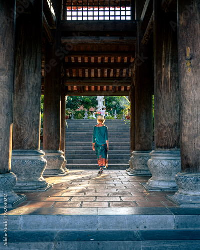woman walking into temple in Vietnam photo