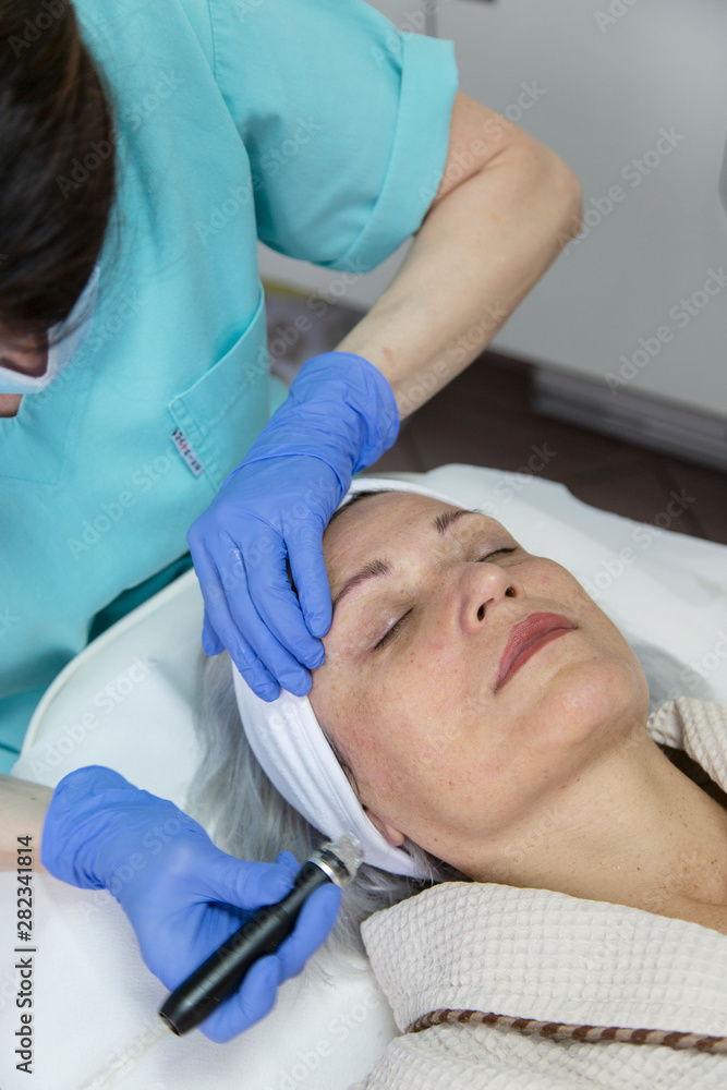 Portrait of middle aged woman having face treatment at beauty clinic Portrait of middle aged woman having face treatment at beauty clinic