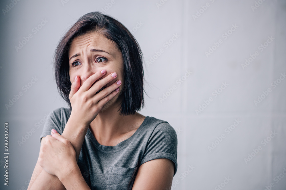 depressed brunette woman covering mouth and crying at home depressed brunette woman covering mouth and crying at home