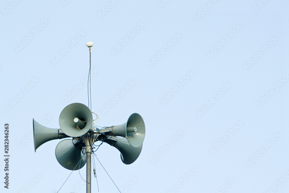 Loudspeakers mounted on a mast against the background of the sky with a spear space Loudspeakers mounted on a mast against the background of the sky with a spear space