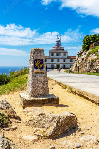 Zero kilometer marker at Cape Finisterre, Cabo Fisterra or Cabo Finisterre - the end of the Way of St. James, Camino de Santiago, Galicia, Spain, the lighthouse in the background