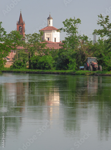 landscape on the outskirts of Milan, church reflected in the navigable canal of the Naviglio Grande