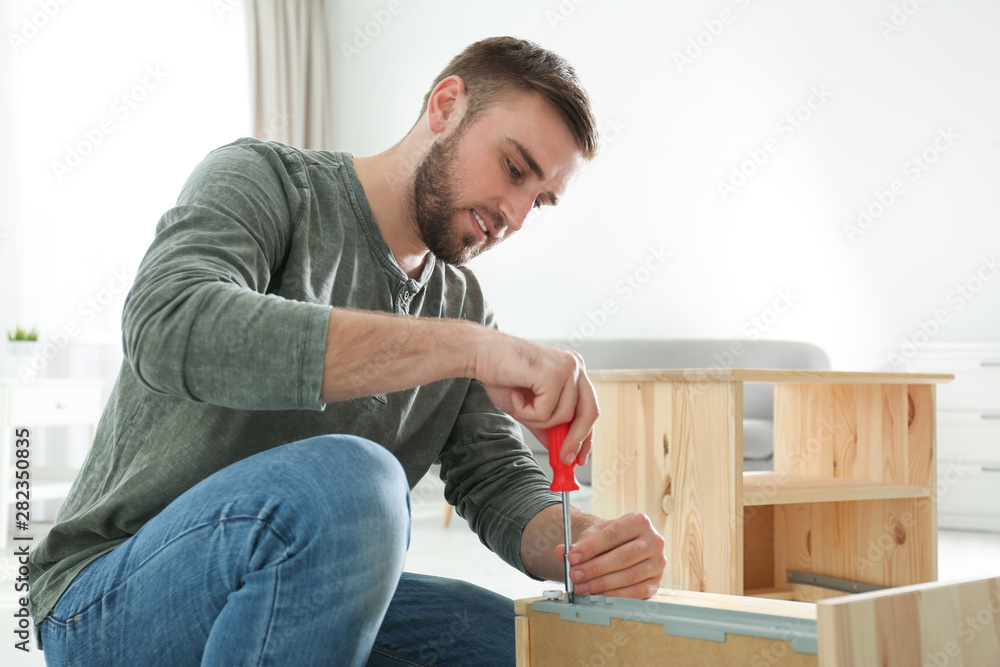 Young working man repairing drawer at home Young working man repairing drawer at home