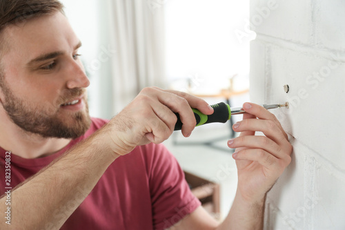 Foto Young working man using screwdriver at home