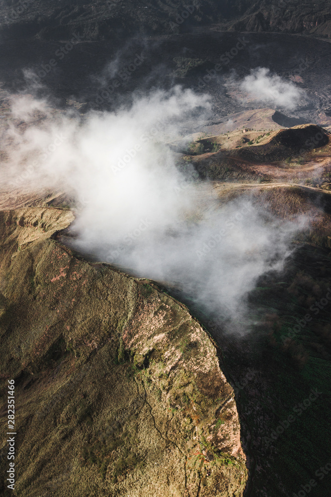 Aerial view of Batur volcano caldera in Bali. Volcanic black texture and crater rim, view from above, drone shot Aerial view of Batur volcano caldera in Bali. Volcanic black texture and crater rim, view from above, drone shot