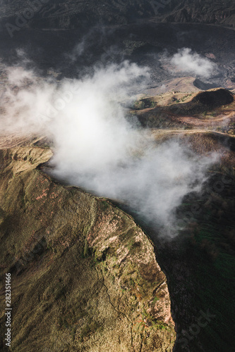 Aerial view of Batur volcano caldera in Bali. Volcanic black texture and crater rim, view from above, drone shot