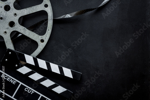 Go to the cinema with film type and clapperboard on black background top view...