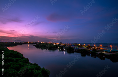 Blurred wallpaper of colorful, twilight sky by the sea, with lights from the street shining at night, beautiful natural occurrences, seen in scenic spots or tourist attractions. B โดย Bangprikphot