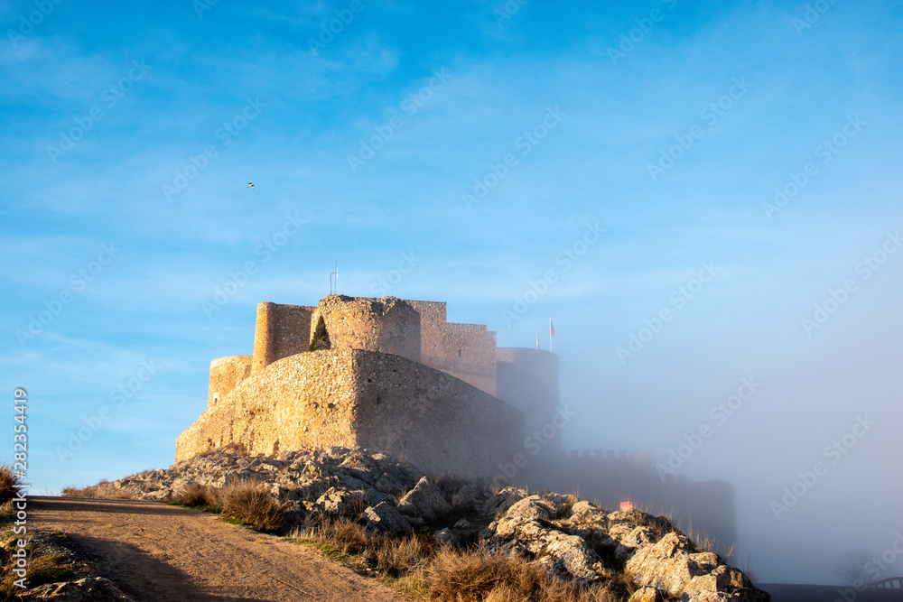 The castle of Consuegra, Spain half in the fog. The castle was built on an ancient Roman fort and was used during the Reconquista.