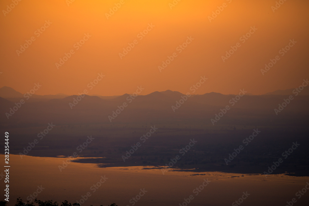 Natural panoramic wallpaper of high mountain scenery, overlooking the atmosphere of rivers, grasslands, roads, and the orange sunshine in the evening, blown through blurred cool air. Natural panoramic wallpaper of high mountain scenery, overlooking the atmosphere of rivers, grasslands, roads, and the orange sunshine in the evening, blown through blurred cool air.