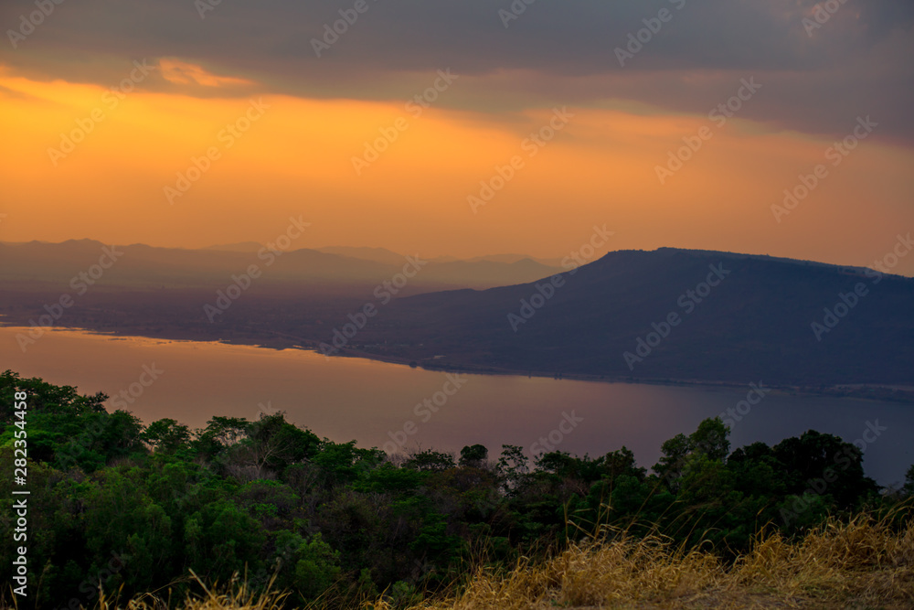 Natural panoramic wallpaper of high mountain scenery, overlooking the atmosphere of rivers, grasslands, roads, and the orange sunshine in the evening, blown through blurred cool air.