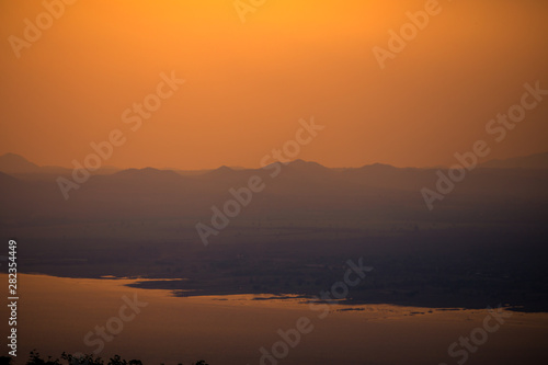 Natural panoramic wallpaper of high mountain scenery  overlooking the atmosphere of rivers  grasslands  roads  and the orange sunshine in the evening  blown through blurred cool air.