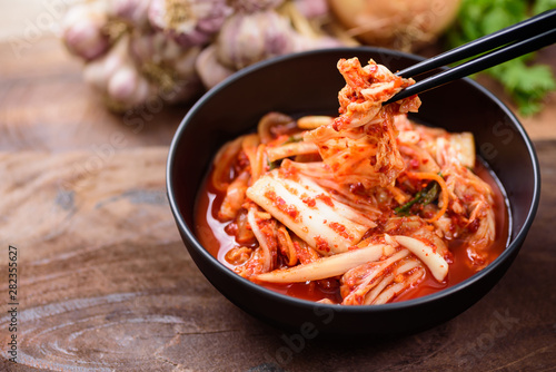Eating kimchi cabbage in a bowl with chopsticks, Korean food photo