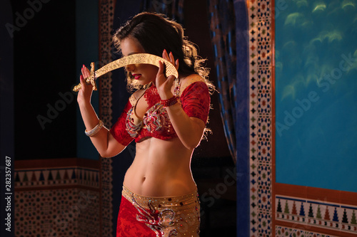 Fotografi Oriental professional belly dancer in carnival shining costume with long healthy glossy hair and cane