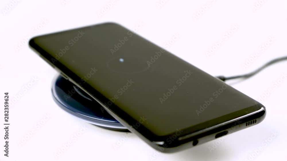 Placing smart phone on wireless phone charger. Placing smart phone on wireless phone charger.
