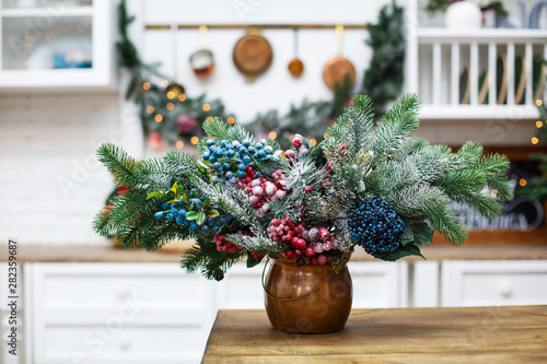 Natural Christmas composition from spruce branches and berries in the kitchen