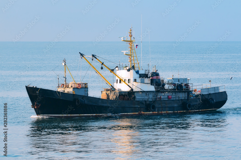 fishing trawler returns to port in the calm