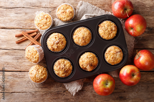 Tasty baked apple muffins with cinnamon close-up in a tray. Horizontal top view