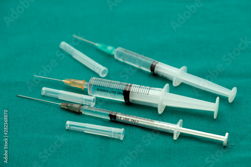Liquid parenteral products in syringe isolated on surgical green drape fabric