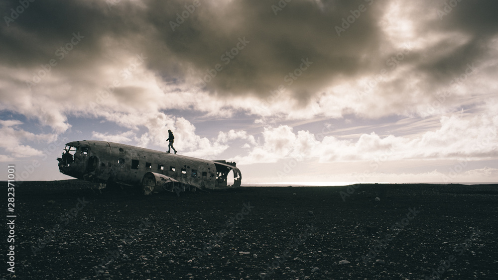 Silhouette of a man walking on a plane wreck in Iceland