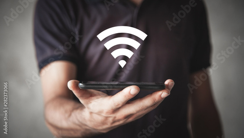 Man holding smartphone with wi-fi sign. Internet, Technology