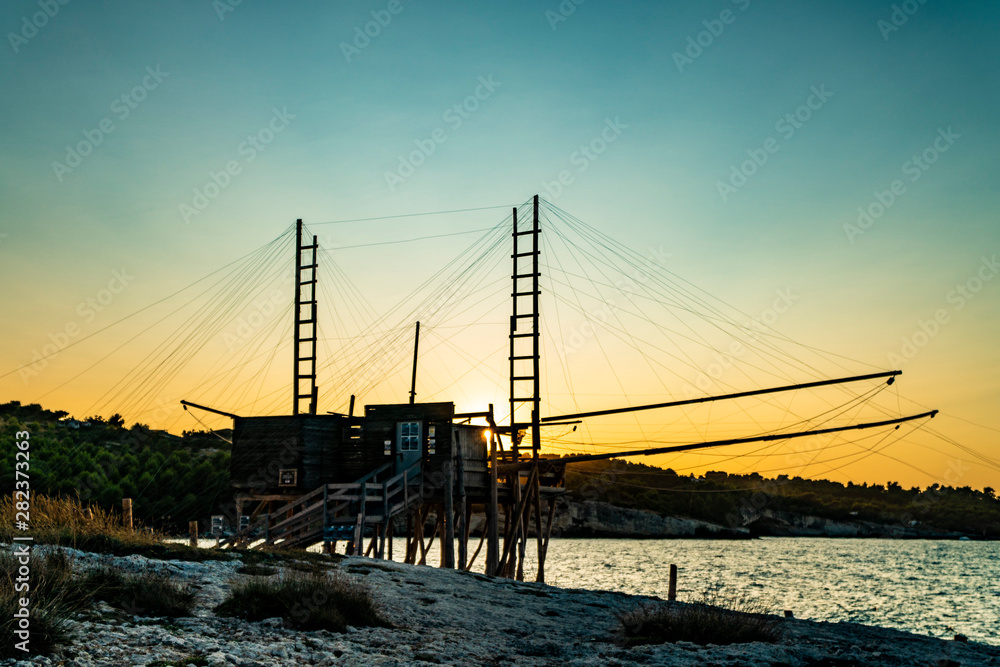 Beautiful seascape with a view of a trabucco at sunset in Italy