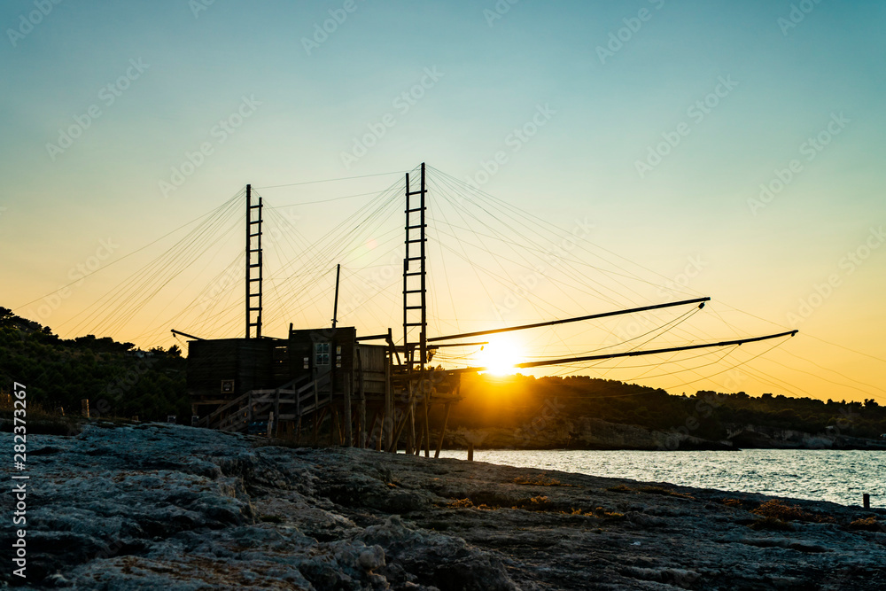 Beautiful seascape with a view of a trabucco at sunset in Italy