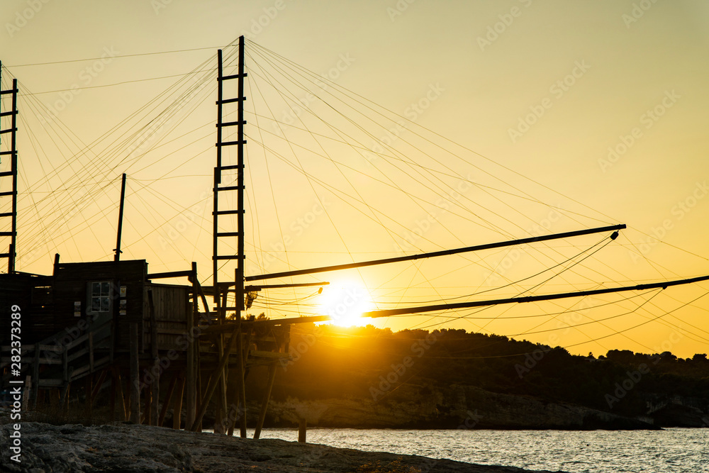 Beautiful seascape with a view of a trabucco at sunset in Italy