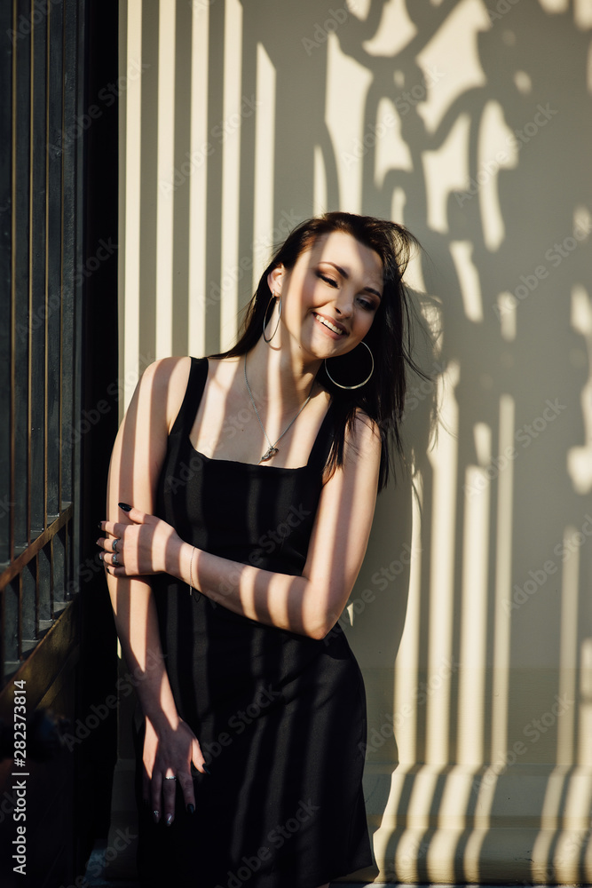 Fototapeta premium Close-up of a face of a young girl who smiles and a shadow from a metal lattice on her face