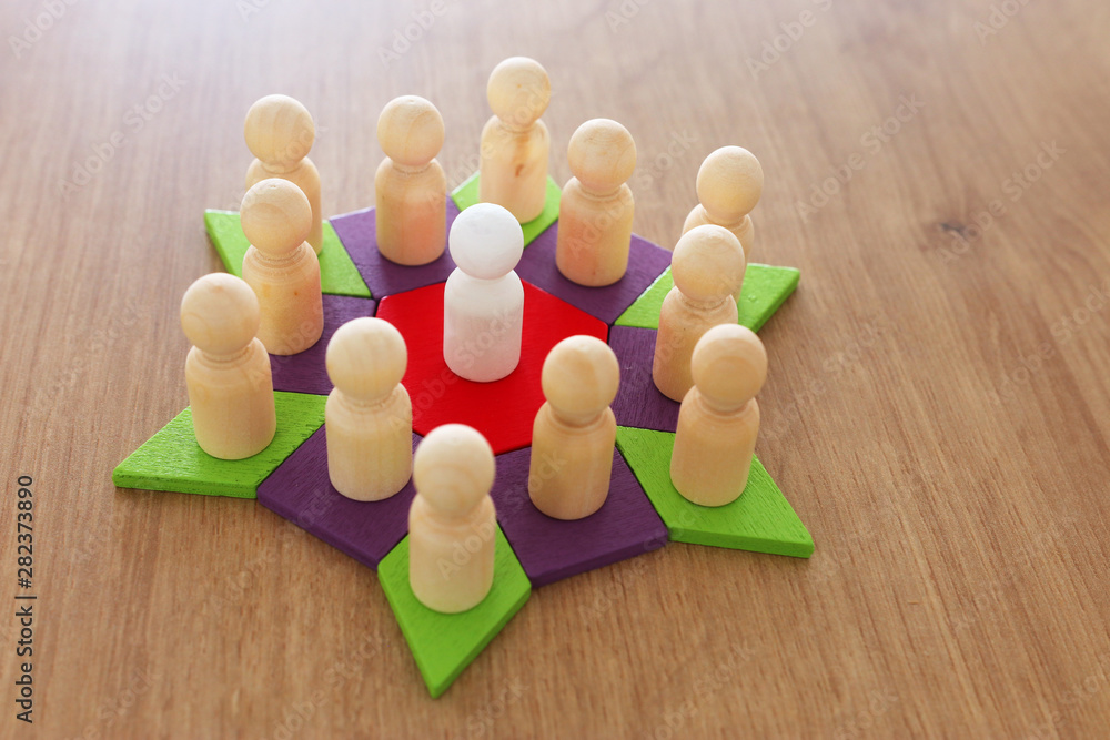 Obraz premium business concept image of tangram puzzle blocks with people figures over wooden table ,human resources and management concept