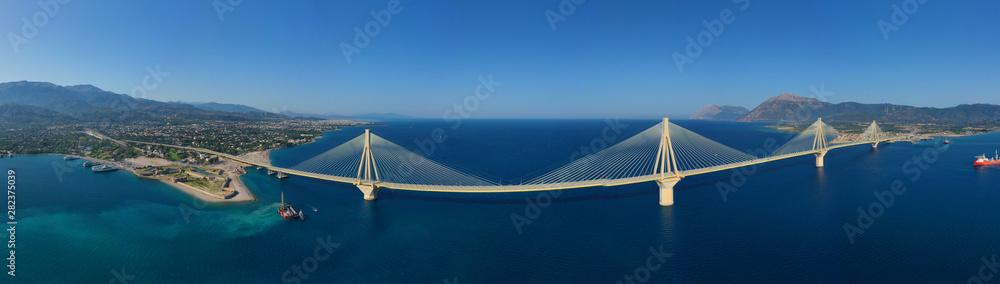 Fototapeta premium Zdjęcie panoramiczne z lotu ptaka drona słynnego na całym świecie wiszącego mostu linowego Rio - Antirio Harilaos Trikoupis, przecinającego Zatokę Koryncką, Grecję kontynentalną na Peloponez, Patras