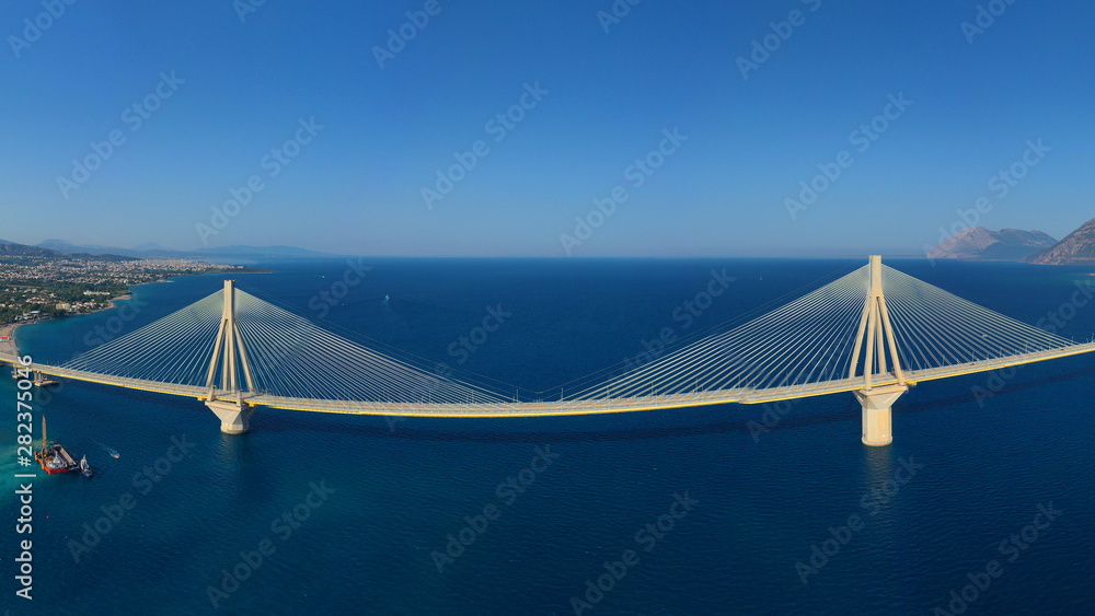 Aerial drone panoramic photo of world famous cable suspension bridge of Rio - Antirio Harilaos Trikoupis, crossing Corinthian Gulf, mainland Greece to Peloponnese, Patras