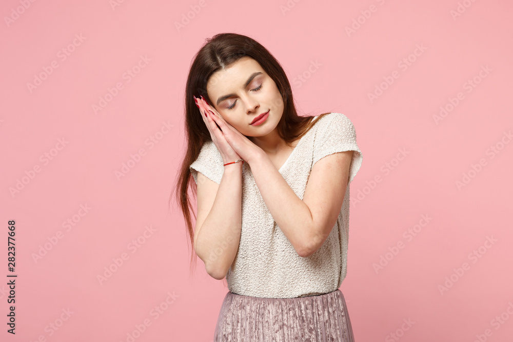 Relaxed young woman in casual light clothes posing isolated on pastel pink wall background, studio portrait. People lifestyle concept. Mock up copy space. Sleeping with folded hands under cheek. Relaxed young woman in casual light clothes posing isolated on pastel pink wall background, studio portrait. People lifestyle concept. Mock up copy space. Sleeping with folded hands under cheek.
