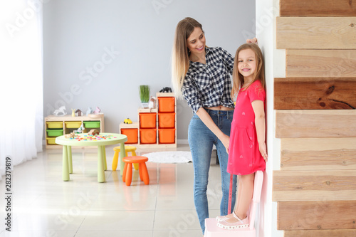 Young mother measuring heig...