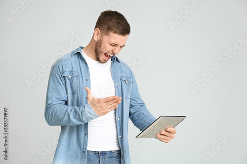 Angry young man with tablet...