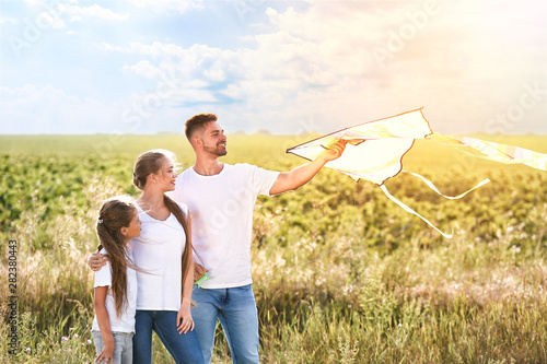 Happy family flying kite in...