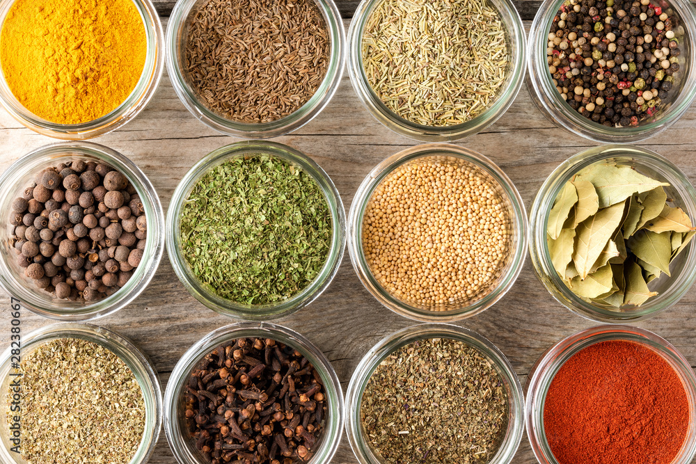 Mix of colourful spices in bowls on wooden table. Collection of seasonings. Top view Mix of colourful spices in bowls on wooden table. Collection of seasonings. Top view