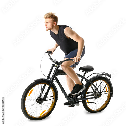 Sporty young man riding bicycle against white background © Pixel-Shot
