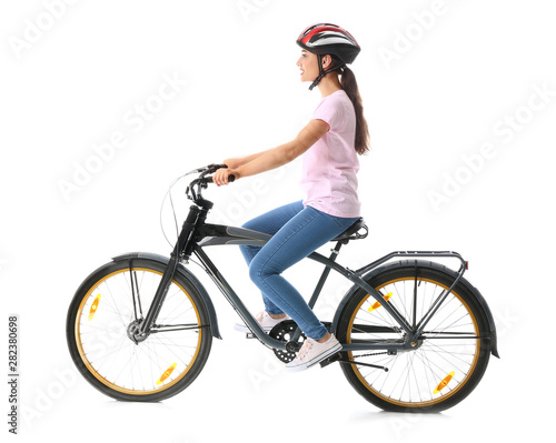 Beautiful young woman riding bicycle against white background