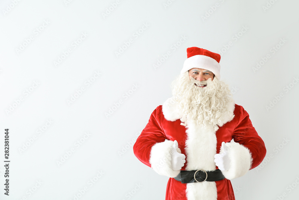 Portrait of Santa Claus showing thumb-up on light background Portrait of Santa Claus showing thumb-up on light background