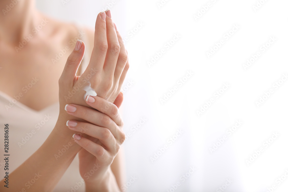 Young woman applying natural cream onto skin at home - obrazy, fototapety, plakaty 