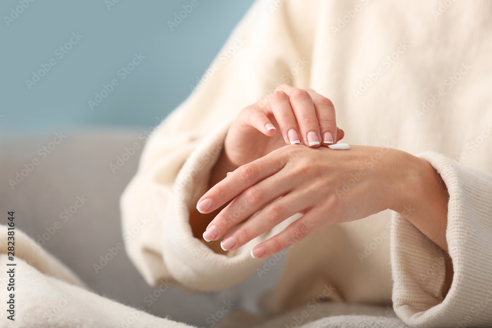 Young woman applying natural cream onto skin at home Young woman applying natural cream onto skin at home